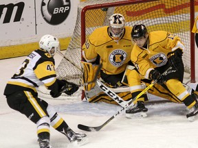Kingston Frontenacs goalie Jeremy Helvig and forward Brett Neumann try to block a shot by Hamilton Bulldogs Michael Cramarossa during Game 1 of Ontario Hockey League Eastern Conference quarter-final action at the Rogers K-Rock Centre on Friday night. Hamilton won 2-0. (Ian MacAlpine /The Whig-Standard)