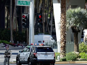 Police officers stand along Las Vegas Blvd., Saturday, March 25, 2017, in Las Vegas. Police say part of the Strip has been closed down after a shooting. (AP Photo/John Locher)
