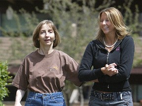 Brain injury victim Linda Taylor (l) takes a walk with health care aide Sarah Haliuk.