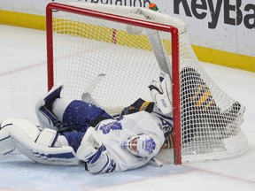 Sabres forward Marcus Foligno crashes into Maple Leafs goalie Curtis McElhinney during the third period on Saturday night in Buffalo. (The Associated Press)