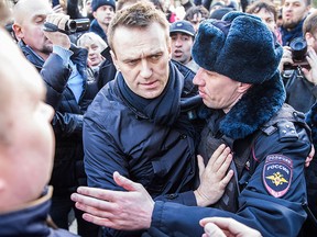 In this photo provided by Evgeny Feldman, Alexei Navalny is detained by police in downtown Moscow, Russia, Sunday, March 26, 2017.  (Evgeny Feldman for Alexey Navalny's campaign photo via AP)
