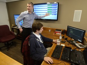 Ben Whitney, of Armo Tool, left explains the monitoring displays during a tour of FreePoint Technologies. At right is FreePoint employee Nicholas Marcon. (MORRIS LAMONT, The London Free Press)