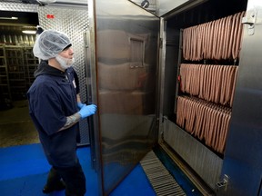 Jade Beckman closes the door on raw sausage ready to be smoked  at Sikorski Sausages in London. The company is planning a large expansion. (MORRIS LAMONT, The London Free Press)