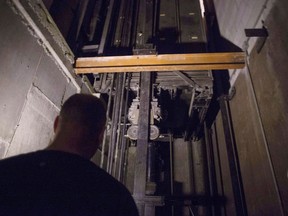 A building manager is pictured in an elevator pit in a downtown Toronto office building in 2016. Liberal MPP Han Dong introduced a bill earlier this week that would hold contractors responsible for getting broken-down elevators up and running in relatively short order. (Chris Young/Canadian Press)