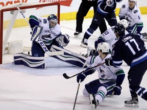 Jets forward Adam Lowry  scores on Vancouver Canucks goaltender Ryan Miller during the third period last night at the MTS Centre. (The Canadian Press)