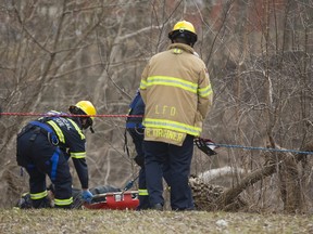 Members of the London fire department?s technical rescue team retrieve a man?s body Sunday from the banks of the Thames River between Richmond and Ridout streets. (MIKE HENSEN, The London Free Press)