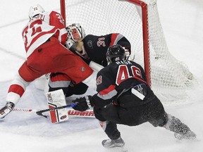 Red Wings forward Andreas Athanasiou (72) collides with Hurricanes goalie Eddie Lack while scoring the game-winning goal during overtime in Raleigh, N.C., on Monday, March 27, 2017. Lack was taken off the ice on a stretcher. (Gerry Broome/AP Photo)