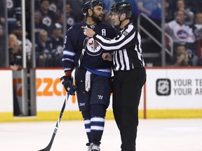 A linesman directs Dustin Byfuglien to the penalty box after he took a high-sticking penalty against the Flames. (Getty Imags)