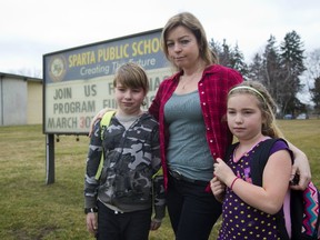 Heather Derks of Sparta is heading the fight to keep the Sparta Public School open, with her are her children Jackson Derks, 8 and Heron Derks, 7 outside their small school on Tuesday. (MIKE HENSEN, The London Free Press)