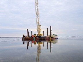 Workers install the pilings for a temporary dock as part of the Amherst Island wind energy project near Millhaven. (Elliot Ferguson/The Whig-Standard)