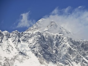 This photograph taken on April 20, 2015 shows a view of Mount Everest (C-top) towering over the Nupse, from the village of Tembuche in the Khumbu region of northeastern Nepal. (Getty)