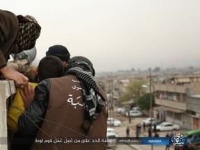 ISIS thugs are pictured as they throw a gay man off a roof in Mosul. (TERROR MONITOR)