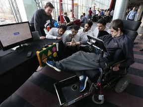 Jorge de Almeida tests out a new foot-controlled remote control TV remote at the University of Ottawa in Ottawa Wednesday March 29, 2017. U of O engineers help design a product for Jorge who does not have use of his arms and hands. Students Matt Lgnaczak, Samir Naik, Prashanth, Harjot Chahal and Abdalla Osman watch Jorge use their invention. TONY CALDWELL / POSTMEDIA NETWORK