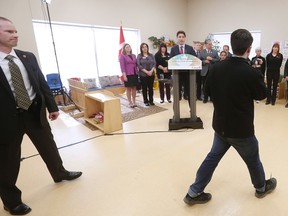 A heckler walks in front of Prime Minister Justin Trudeau as he speaks at a YMCA-YWCA day care centre in Winnipeg, Wednesday, March 29, 2017. Trudeau was in Winnipeg to highlight $7 billion over 10 years to create more child care spaces across Canada.