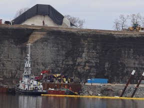 Tim Meeks/The Intelligencer
Workers attempt to right a partially submerged barge in Picton Bay Wednesday morning. The barge sunk Tuesday afternoon, leaking fuel that threatened to contaminate the Picton-Bloomfield drinking water system. The City of Prince Edward County declared a state of water emergency as a precaution until the safety of the water could be confirmed.