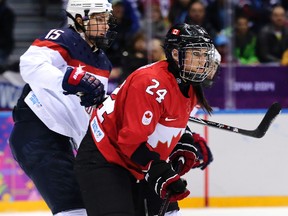 Canada's Natalie Spooner (right) looks intensely up the ice under the watchful eye of USA's Anne Schleper during the women's ice hockey gold medal game at the Sochi Winter Olympics in Sochi, Russia, on Feb. 20, 2014. (Al Charest/Postmedia Network/Files)
