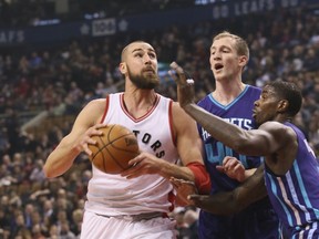 Raptors centre Jonas Valanciunas (left) drives to the basket against Hornets defenders during NBA action at the Air Canada Centre in Toronto on Wednesday, March 29, 2017. (Veronica Henri/Toronto Sun)