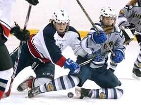 Hailey Sprack of the Marymount Academy Regals battles for the puck with Sydney Hall of the Bishop Alexander Carter Gators during girls high school hockey division 2 championship game action in Sudbury, Ont. on Wednesday March 29, 2017. Gino Donato/Sudbury Star/Postmedia Network