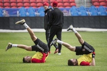 Johan Brunell and Drew Moor, left, get in a stretch as Toronto FC took to BMO Field Wednesday morning to prepare for Friday night’s home opener vs. Sporting KC. (Craig Robertson, Toronto Sun)