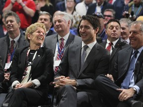 Prime Minister Justin Trudeau, centre, Ontario Premier Kathleen Wynne and President of the Americas Ford Motor Company Joe Hinrichs laugh during an announcement at the Ford Essex Engine Plant in Windsor, Ont. on Thursday, March 30, 2017. THE CANADIAN PRESS/Dave Chidley