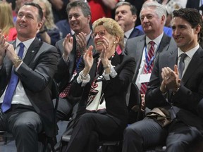 Prime Minister Justin Trudeau, Ontario Premier Kathleen Wynne and Mark Buzzell, president and CEO of Ford Motor Company of Canada, applaud during an announcement at the Ford Essex Engine Plant in Windsor, Ont. on Thursday, March 30, 2017. DAVE CHIDLEY / THE CANADIAN PRESS