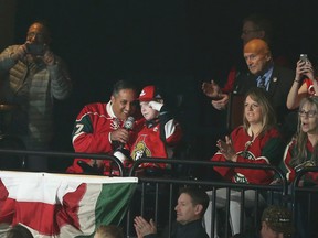 Canadians Consul General Khawar Nasim, center left, and Jonathan Pitre, right, help with the call out the "Let's Play Hockey" arena tradition prior to the start of the Minnesota Wild Ottawa Senators game on Thursday, March 30, 2017, in St. Paul, Minn.  AP