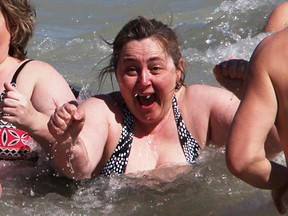 Caroline Bekkers reacts after she and others waded into crisp Lake Huron waters for the Canadian Cancer Society's inaugural Daffodil Dip event in 2016. The cold-water dip returns April 22 as part of the cancer society's Daffodil Month. (Tyler Kula/Sarnia Observer)