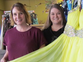 Debbie Anderson, left, and Julie Stewardson, with Sarnia's Cinderella Story, are shown Friday with one of more than 1,200 dresses ready for this year's dress selection boutique, running Friday evening and Saturday at 100 Christina St., in Sarnia. Volunteers with the project were expecting to help approximately 100 girls find a dress, at no cost, for prom and graduation. (Paul Morden/Sarnia Observer)