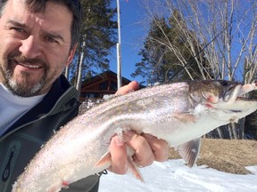 Columnist Frank Clark lifts up a beautiful three-pound brook trout caught in early April on the Vermillion River in front of his residence. Photo supplied.