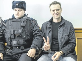 Russian opposition leader Alexei Navalny shows a V-sign for the media in court in Moscow, Russia, Thursday as Russian President Vladimir Putin rejects Western calls for the release of jailed protesters, including Navalny. (Evgeny Feldman/AP Photo)