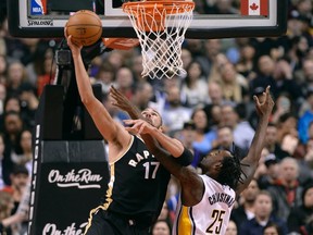 Pacers forward Rakeem Christmas (right) collects a foul as Raptors centre Jonas Valanciunas (left) sinks a basket during second half NBA action in Toronto on Friday, March 31, 2017. (Nathan Denette/The Canadian Press)