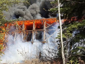 Fire engulfs a Canadian National Railway bridge on the outskirts of Mayerthorpe in this image provide by the Town of Mayerthorpe, Alberta on Tuesday April 26, 2016. The fire started Tuesday afternoon forcing students at the nearby Mayerthorpe high school and residents of 38 mobile homes at the Kreek's Krossing trailer park to leave. THE CANADIAN PRESS/HO-Town of Mayerthorpe