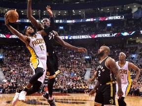 Raptors’ Serge Ibaka goes up to defend against Pacers’ Paul George during Friday night’s game. (THE CANADIAN PRESS)
