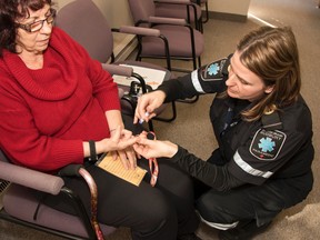 A patient of the community paramedic health promotion clinic has her blood sugar level checked. (Mary Katherine Keown/The Sudbury Star)