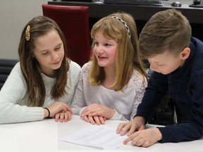 Jaymie Cowen, 12, Karissa Kern, 10, and Noah Leonard, 11, review a list of songs at a Friday meeting for the upcoming Sarnia Sings event. The fundraising concert -- set for May 4 at the Imperial Theatre -- will feature 16 local performers accompanied by a live band. Proceeds from the concert benefit mental health and suicide prevention causes through the Sarnia Community Foundation. Barbara Simpson/Sarnia Observer/Postmedia Network