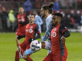 Sporting Kansas City’s Graham Zusi clears the ball from Toronto FC’s Raheem Edwards during Friday night’s game at BMO Field. (THE CANADIAN PRESS)