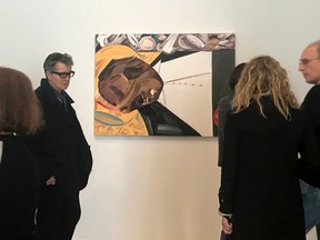 A group of museum-goers examine a painting entitled "Open Casket" by artist Dana Schutz at the Whitney Museum of American Art in New York, Thursday, March 23, 3017. The painting, made with the aid of historical photographs of Emmett Till as he lay in his casket, has left some gravely displeased and triggered outcry. Till was a 14-year-old black teenager when he was killed by white men in 1955 for allegedly whistling at a white woman. (AP Photo/Alina Heineke)