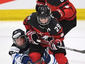 Canada’s Marie-Philip Poulin (right) and Finland’s Rikka Valila vie for the puck during the IIHF Ice Hockey Women’s World Championship in Plymouth, Mich., Saturday. Canada lost 4-3. (The Canadian Press)