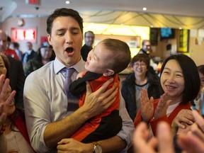 Prime Minister Justin Trudeau picks up a small child as he visits the Fancy Chinese Cuisine Restaurant in Markham, Ont., with Mary Ng Liberal Candidate for the federal riding of Markham-Thornhill, on March 31, 2017. THE CANADIAN PRESS/Chris Young