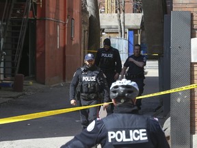 Toronto Police and forensic officers investigate an illegal after-hours club in downtown Toronto where a 24-year-old man and 30-year-old woman were shot around 4:30 a.m., Sunday, April 2, 2017. Both suffered life-threatening wounds, according to police. (JACK BOLAND/TORONTO SUN)