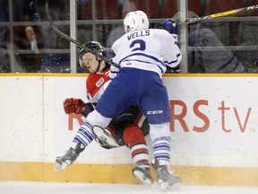 Mississauga Steelheads’ Ryan Wells hits Ottawa 67’s forward Artur Tyanulin into the boards during yesterday’s game. (PATRICK DOYLE/Postmedia Network)