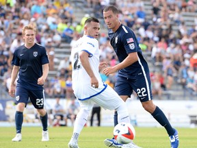Jacksonville Armada FC defender Kalen Ryden, right, plays the ball past FC Edmonton defender Shawn Nicklaw, while Armada midfielder Zack Steinberger looks on during North American Soccer League play in Jacksonville, Fla., on April 2, 2017. (Supplied/Jacksonville Armada FC)