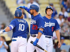 Los Angeles Dodgers’ Justin Turner, left, is congratulated by Adrian Gonzalez and Corey Seager after hitting a two-run home run against the Los Angeles Angels Saturday, April 1, 2017, in Los Angeles. (AP Photo/Mark J. Terrill)