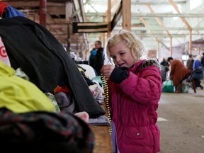 Layla Matheson, 6, from London looks through some clothes at Reuseapalooza at the Woodstock Fairgrounds on Saturday. (BRUCE CHESSELL/Sentinel-Review)