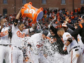 Baltimore Orioles’ Mark Trumbo, centre, is doused with water by teammates as he runs crosses home plate after hitting a solo home run in the 11th inning against the Toronto Blue Jays in Baltimore, Monday, April 3, 2017. (AP Photo/Patrick Semansky)