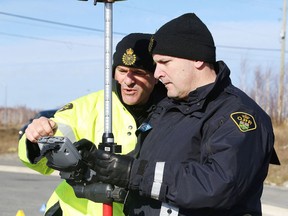 Constable Terry Yeomans, an OPP reconstructionist, gives some instructions to Constable Pete McKee of the North Bay OPP during a training exercise in using forensic mapping equipment in Sudbury this past November. (Gino Donato/Sudbury Star file photo)