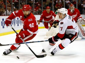 Red Wings’ Henrik Zetterberg (left) tries to control the puck next to the Senators’ Kyle Turris in Detroit last night. (Getty Images)