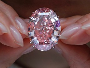 In this Wednesday, March 29, 2017, file photo, the "Pink Star" diamond, the most valuable cut diamond ever offered at auction, is displayed by a model at a Sotheby's auction room in Hong Kong. The stunning 59.6 carat diamond has sold for HK$553 million or US$71.2 million at a Sotheby's auction in Hong Kong, setting a record for any diamond or jewel. It's Also the highest price for any work ever sold at auction in Asia. (AP Photo/Vincent Yu, File)