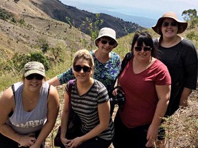Katelyn Neville, left, and Holly Rogers, front left, were among eight Lambton College students to visit Haiti in February as part of an awareness trip. They're pictured with instructor Janine Kirby, centre, and students Jennifer Dillon, in red, and Heather Fraser after their truck overheated on a mountain and three Haitians stopped to help them get the vehicle running again. (Submitted)