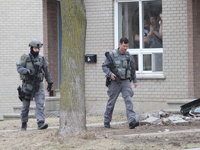 Kingston Police emergency response unit conducted an operation around a unit on Compton Street on Monday afternoon. They later found the man they were looking for dead in his unit.  (Ian MacAlpine /The Whig-Standard)